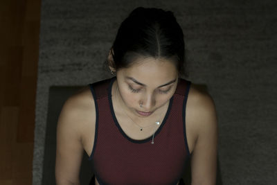 Young woman looking away against wall