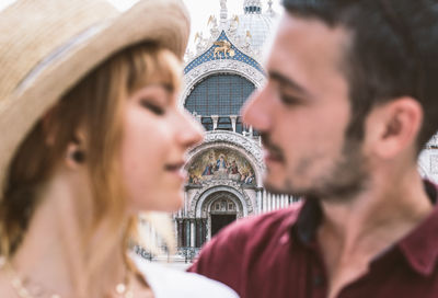 Close-up of young couple with cathedral in background