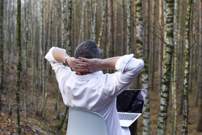 Rear view of man standing in forest