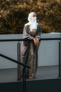 Rear view of woman standing by railing