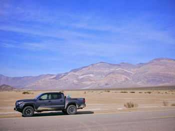 A toyota truck parked on the side of a desert highway, death valley