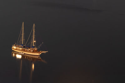 Sailboat sailing in sea against sky at night