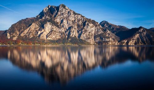 Scenic view of lake and mountains against blue sky