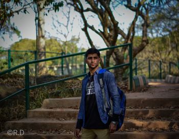 Portrait of young man standing on staircase