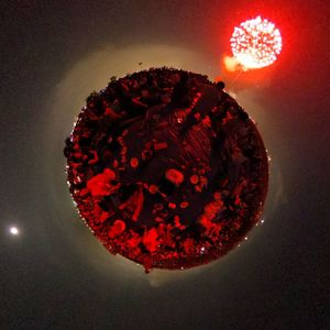 Close-up of illuminated red light against sky at night