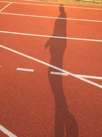 Shadow of man on running track