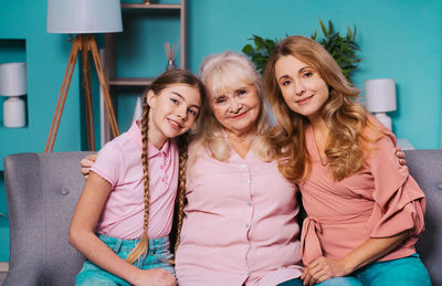 Portrait of cheerful family sitting on sofa at home