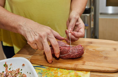 Chef ties the meat with special rope to make meat rolls. french gourmet cuisine