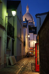 Narrow street amidst buildings at night