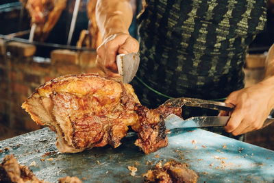 Close-up of man preparing food on barbecue grill