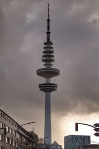 Low angle view of tv tower against cloudy sky