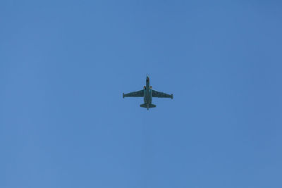 Low angle view of military airplane against clear blue sky