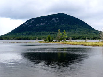 Scenic view of lake by mountains against sky