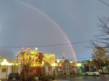 Low angle view of rainbow over buildings in city