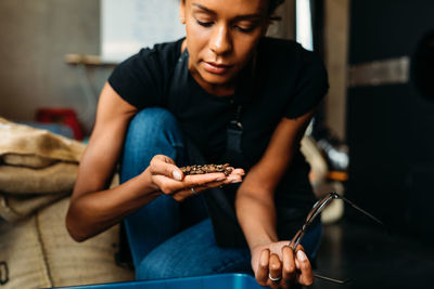 Young woman looking coffee beans in cafe