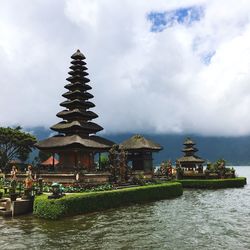 Temple in city against cloudy sky