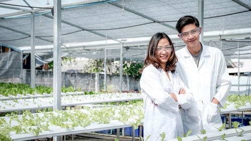 Portrait of a smiling man standing in greenhouse