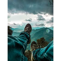 Low section of people by trees against sky