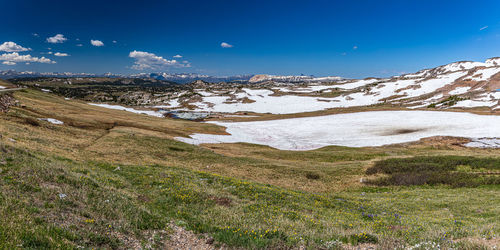 Scenic view of snowcapped mountains against blue sky