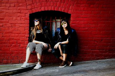 Full length of young woman standing on wall