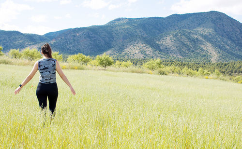 Rear view of woman on field against sky