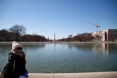Portrait of woman standing against washington monument during sunny day