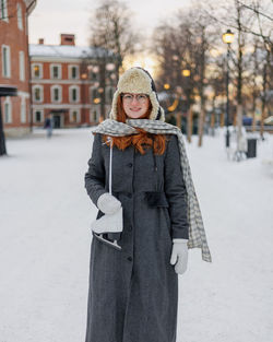 Portrait of young woman standing on snow