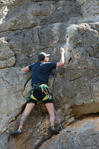 Low angle view of man rock climbing