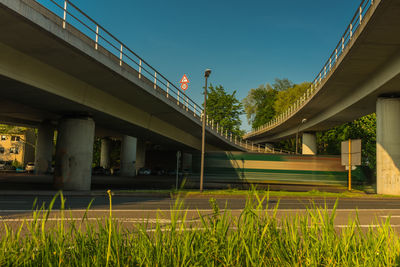 Low angle view of bridge amidst buildings against sky