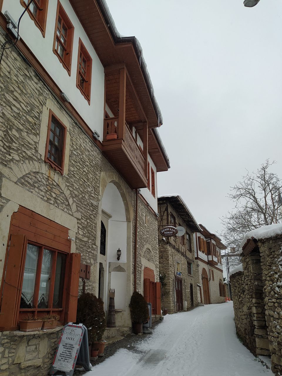 SNOW COVERED HOUSES AMIDST BUILDINGS IN CITY