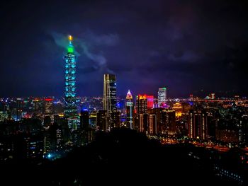 Illuminated cityscape against sky at night