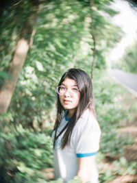 Portrait of smiling young woman standing on land