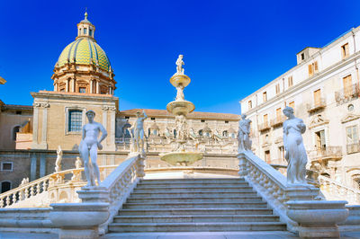 Low angle view of statues on building against sky