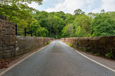 Road amidst trees against sky