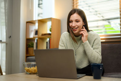 Young woman using laptop at home