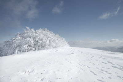 Snow covered landscape against sky