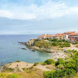 Scenic view of sea by buildings against sky