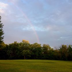 Scenic view of rainbow over landscape against sky