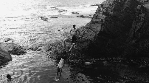 Man standing on rock by sea