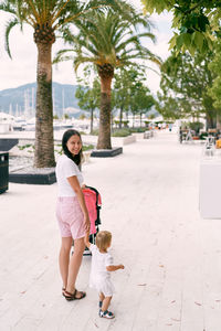 Mother and daughter by tree against plants