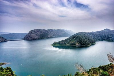 Scenic view of sea and mountains against sky