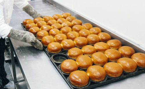 Low section of chef baking breads in kitchen