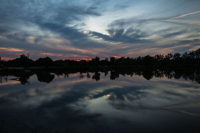 Scenic view of calm lake against cloudy sky