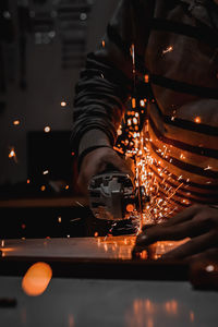 Low angle view of man working at illuminated factory