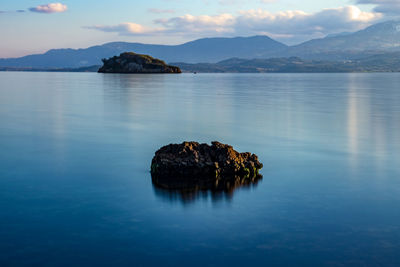 Scenic view of sea and mountains against sky