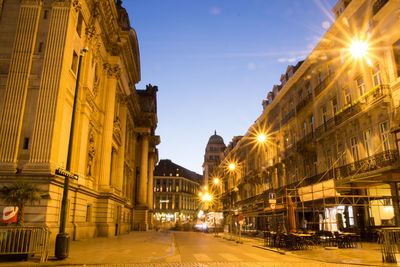 Illuminated city street and buildings at night