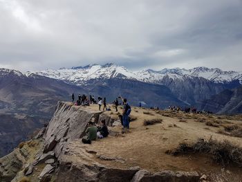 Hikers enjoying on mountain against sky