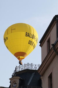 Low angle view of yellow lanterns hanging against clear sky