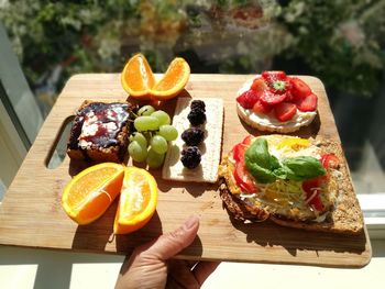 Close-up of hand holding food on cutting board