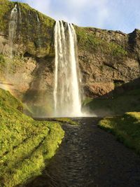 Scenic view of waterfall against sky